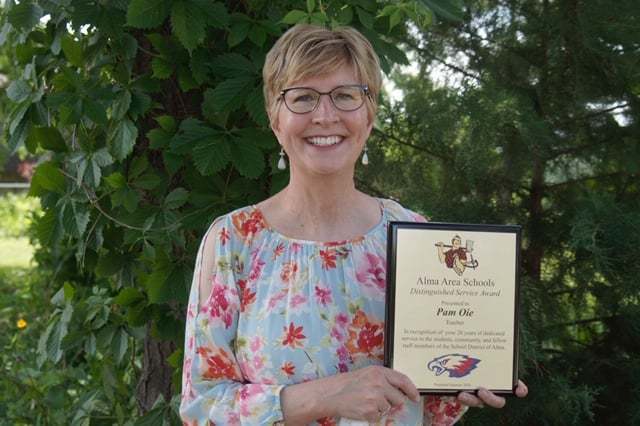 Pam holds her Distinguished Service Award.